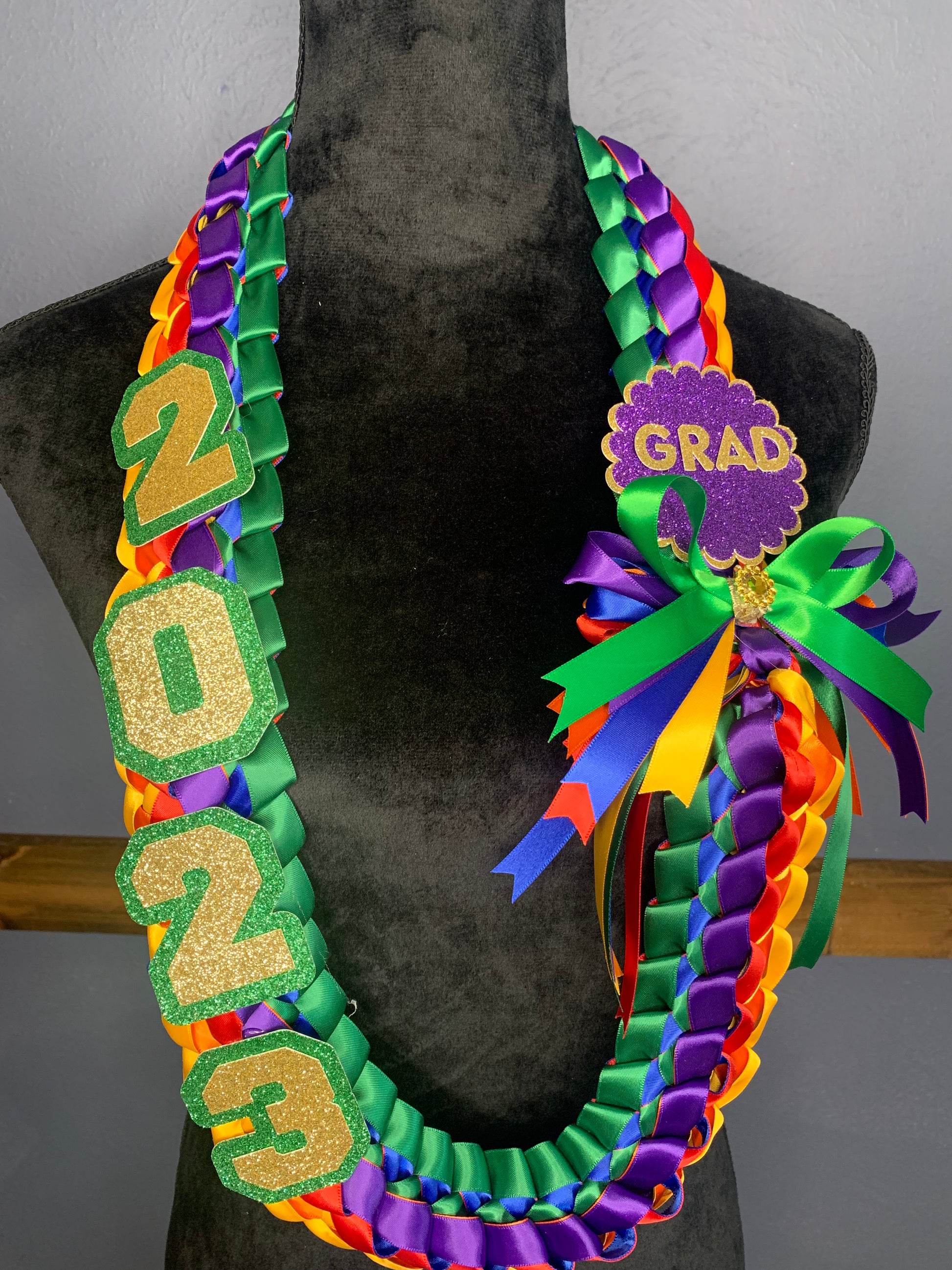 All Graduation Leis include grad year, a bow and a name or other embellishment such as grad cap, heart, "grad".